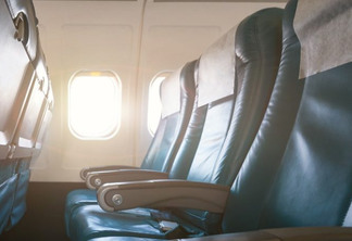 Interior of airplane with empty seats and sunlight at the window. Travel concept.