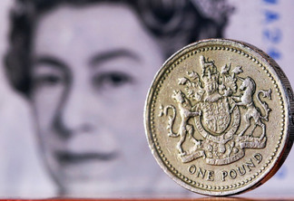 A one pound sterling coin sits in front of a British five pound banknote in this arranged photograph in London, U.K., on February 9, 2016. The pound has been falling versus the dollar since the middle of 2015 and accelerated its slide this year, reaching an almost seven-year low of $1.4080 on Jan. 21.