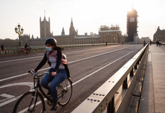 A cyclist wearing a face mask rides across a near-deserted Westminster Bridge in London, England, on April 8, 2020. With the country not predicted to reach its covid-19 coronavirus 'peak' for another week or more, the current lockdown conditions in place across the UK are widely expected to be extended in the coming days beyond the looming end, next Monday, of the three-week period of restrictions that was initially imposed. The matter is reportedly set to be addressed by Foreign Secretary Dominic Raab at Thursday's daily press conference. Raab is presently deputising for Prime Minister Boris Johnson, who tested positive for covid-19 last month and is currently in intensive care at St Thomas' Hospital in London. Across the UK, meanwhile, 60,733 people have now tested positive for the coronavirus, with 7,097 having died. (Photo by David Cliff/NurPhoto via Getty Images)